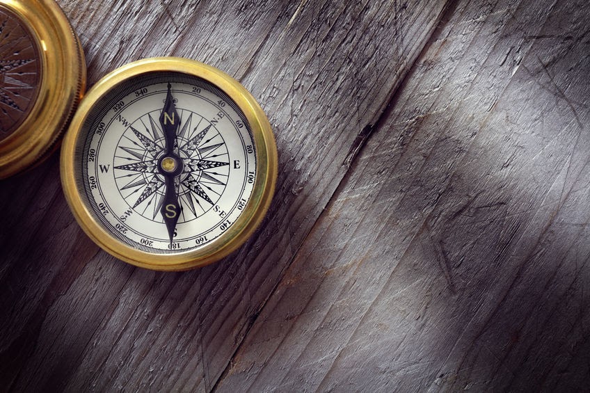 A compass on a wooden table.