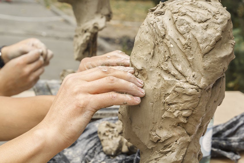 Hands forming a clay sculpture. God formed us at the beginning and continues to form us today.